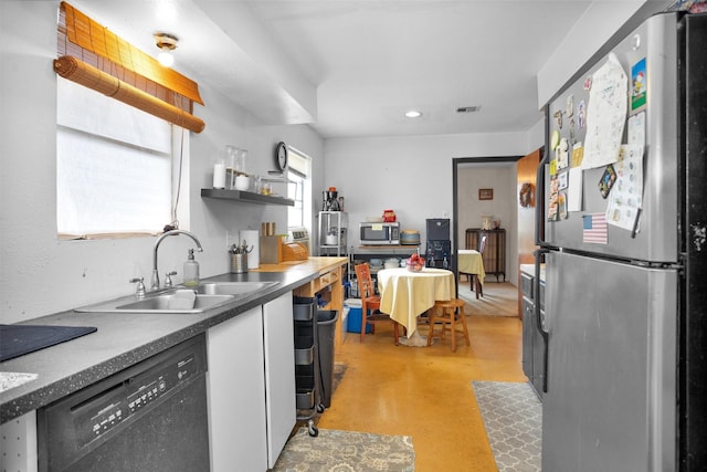 kitchen with a sink, concrete flooring, stainless steel appliances, visible vents, and white cabinetry
