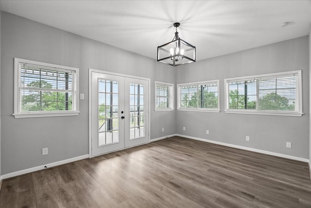 interior space featuring baseboards, a notable chandelier, french doors, and dark wood-type flooring