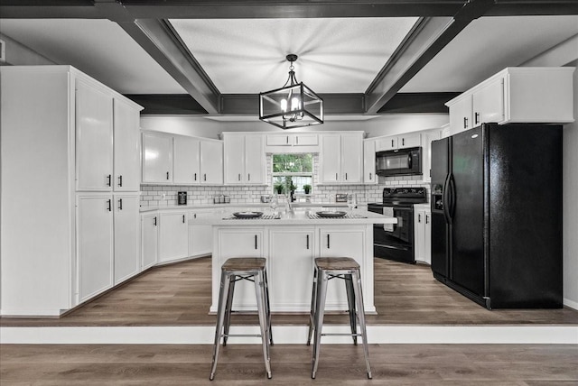 kitchen with black appliances, light countertops, white cabinets, and backsplash