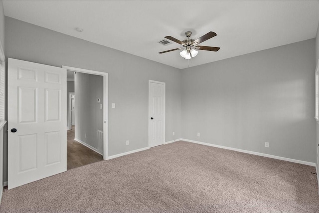 unfurnished bedroom with a closet, ceiling fan, visible vents, baseboards, and carpet floors