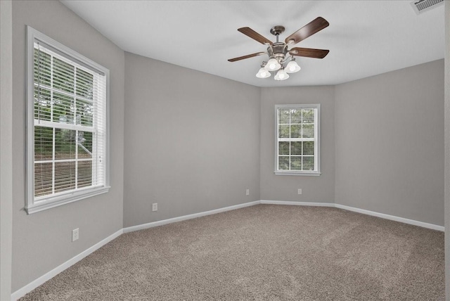 spare room featuring visible vents, carpet flooring, a ceiling fan, and baseboards