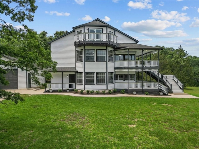 back of house featuring stairs, covered porch, a yard, and a balcony
