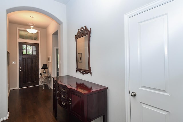 foyer with dark wood-type flooring, arched walkways, and visible vents