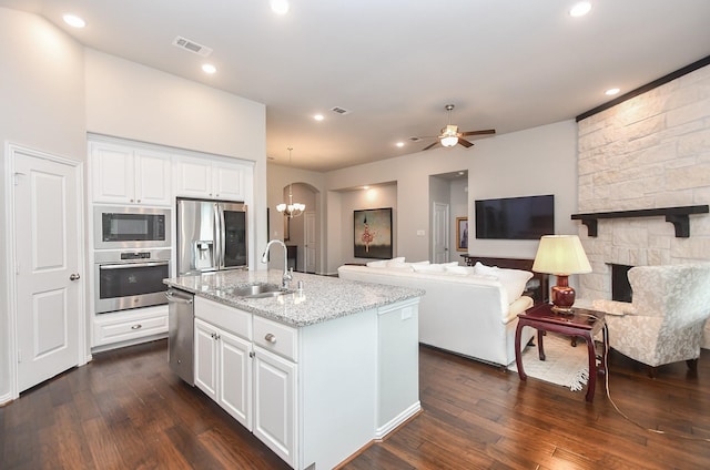 kitchen with visible vents, dark wood-style flooring, light stone countertops, a sink, and appliances with stainless steel finishes