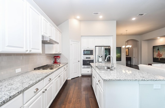 kitchen with visible vents, dark wood-type flooring, under cabinet range hood, a sink, and stainless steel appliances