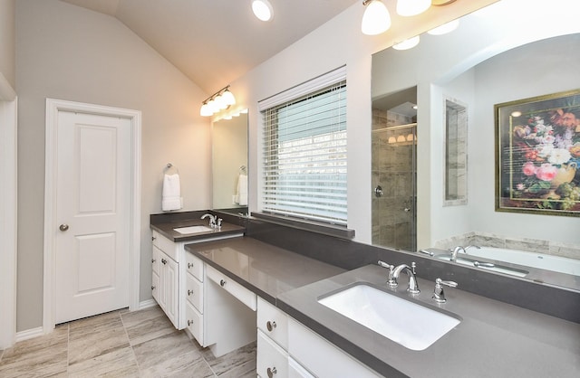 full bathroom with double vanity, a sink, lofted ceiling, and a stall shower