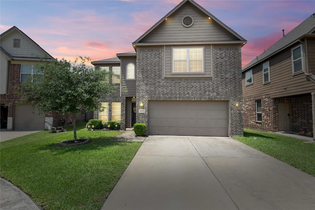 traditional-style home with a lawn, concrete driveway, an attached garage, and brick siding