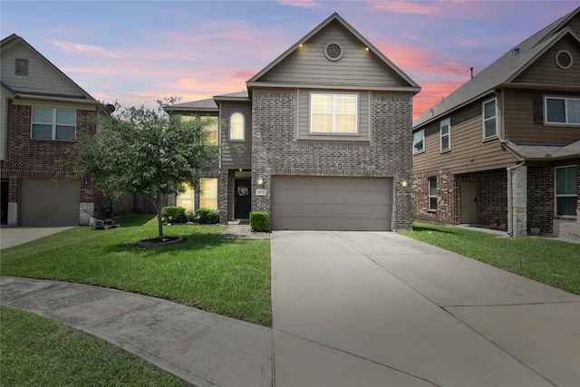 traditional-style home with a yard, concrete driveway, brick siding, and an attached garage