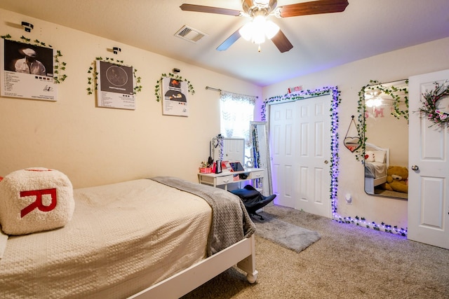 carpeted bedroom featuring visible vents, ceiling fan, and a closet