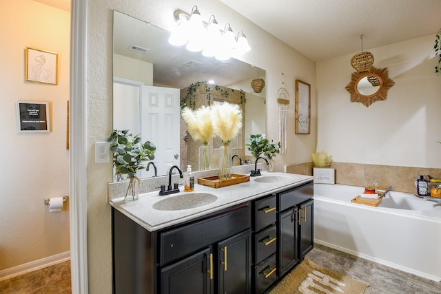full bathroom with double vanity, a garden tub, visible vents, and a sink