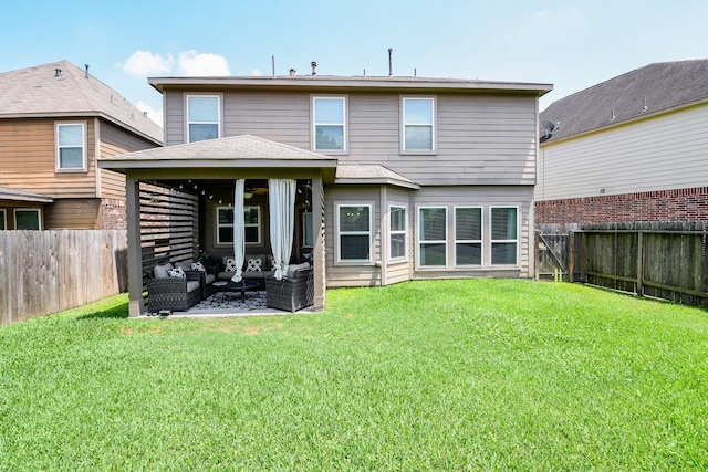 rear view of property with a lawn, an outdoor hangout area, a gazebo, and a fenced backyard