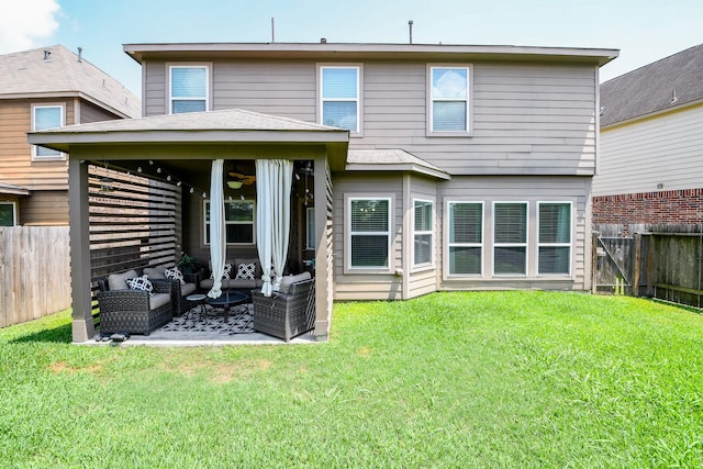 rear view of house featuring a patio area, outdoor lounge area, ceiling fan, a lawn, and a fenced backyard