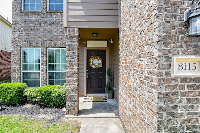 view of exterior entry featuring brick siding
