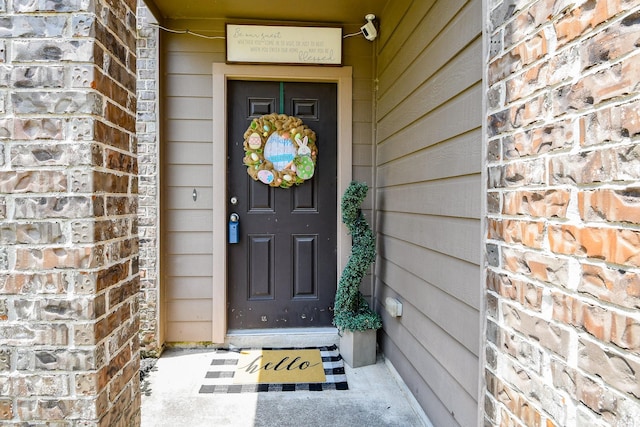 entrance to property featuring brick siding
