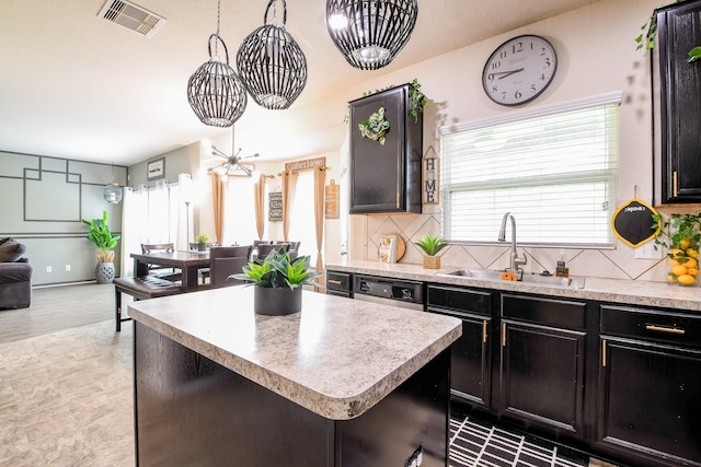 kitchen with visible vents, light countertops, decorative backsplash, and a sink