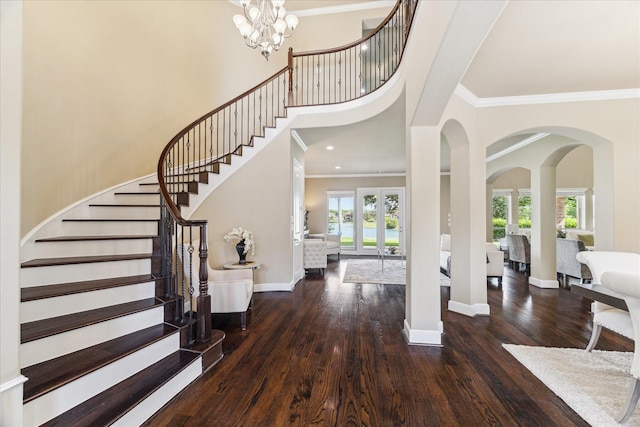 foyer with baseboards, ornamental molding, wood finished floors, and stairway
