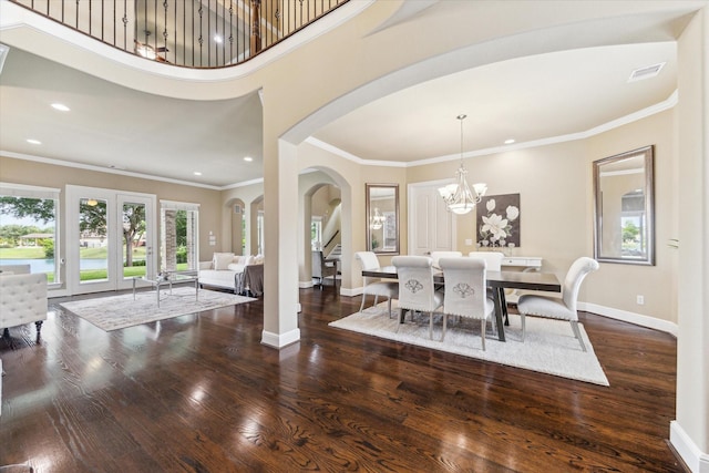 dining space with visible vents, arched walkways, plenty of natural light, and wood finished floors