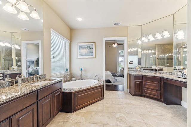 bathroom with a sink, ensuite bath, ceiling fan with notable chandelier, two vanities, and visible vents
