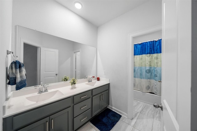 bathroom with double vanity, shower / tub combo with curtain, baseboards, and a sink