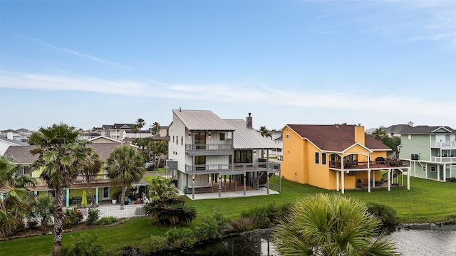 rear view of house with a patio area, a residential view, a yard, and a balcony
