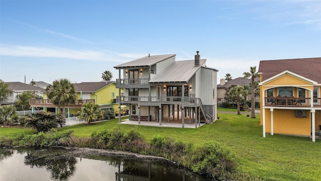 back of house with a patio, a lawn, a chimney, and a balcony