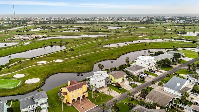 drone / aerial view with golf course view, a residential view, and a water view