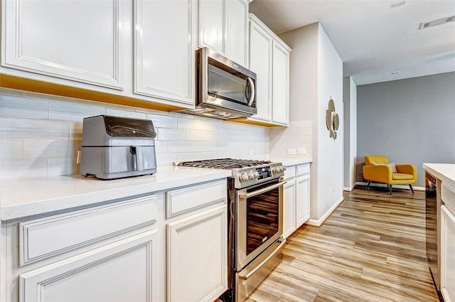 kitchen featuring visible vents, stainless steel appliances, and light countertops