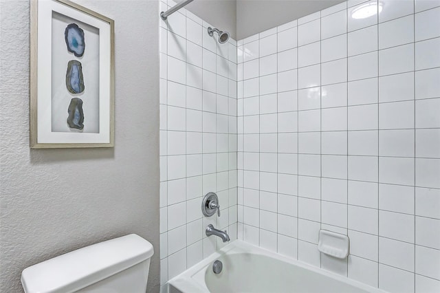 full bathroom featuring shower / bathing tub combination, a textured wall, and toilet