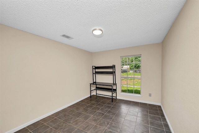 20983 Westgrove Ln, Porter, TX 77365 - unfurnished room featuring a textured ceiling, dark tile patterned flooring, baseboards, and visible vents
