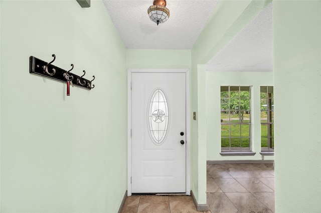 20983 Westgrove Ln, Porter, TX 77365 - foyer with baseboards, light tile patterned flooring, and a textured ceiling