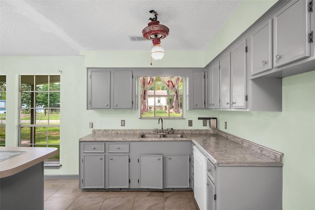 20983 Westgrove Ln, Porter, TX 77365 - kitchen featuring gray cabinetry, a textured ceiling, and a sink