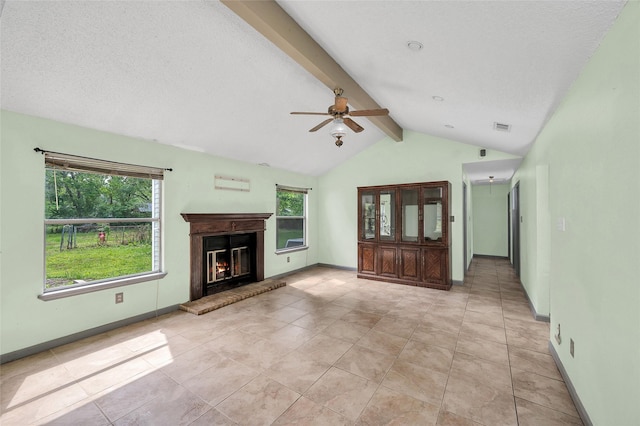 20983 Westgrove Ln, Porter, TX 77365 - unfurnished living room with plenty of natural light, lofted ceiling with beams, ceiling fan, and a glass covered fireplace