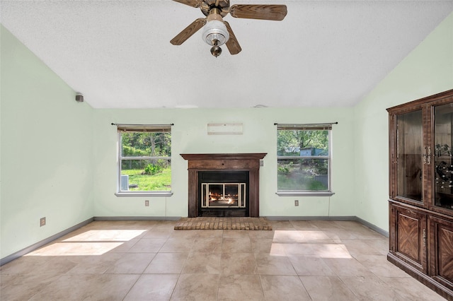 20983 Westgrove Ln, Porter, TX 77365 - unfurnished living room featuring light tile patterned floors, a ceiling fan, baseboards, vaulted ceiling, and a warm lit fireplace