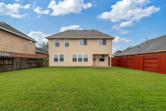 back of property featuring a fenced backyard and a yard