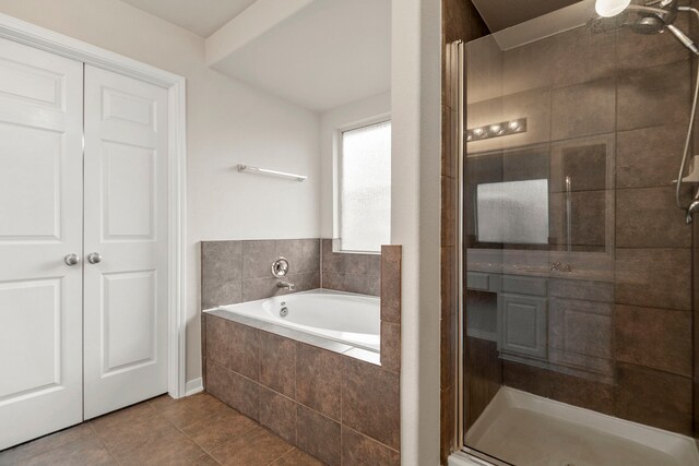 bathroom with tile patterned flooring, a shower stall, and a bath