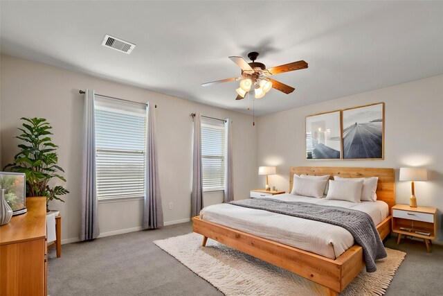 bedroom featuring visible vents, baseboards, ceiling fan, and light carpet