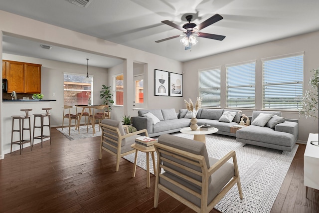 living room with visible vents, dark wood-style flooring, ceiling fan, and a healthy amount of sunlight