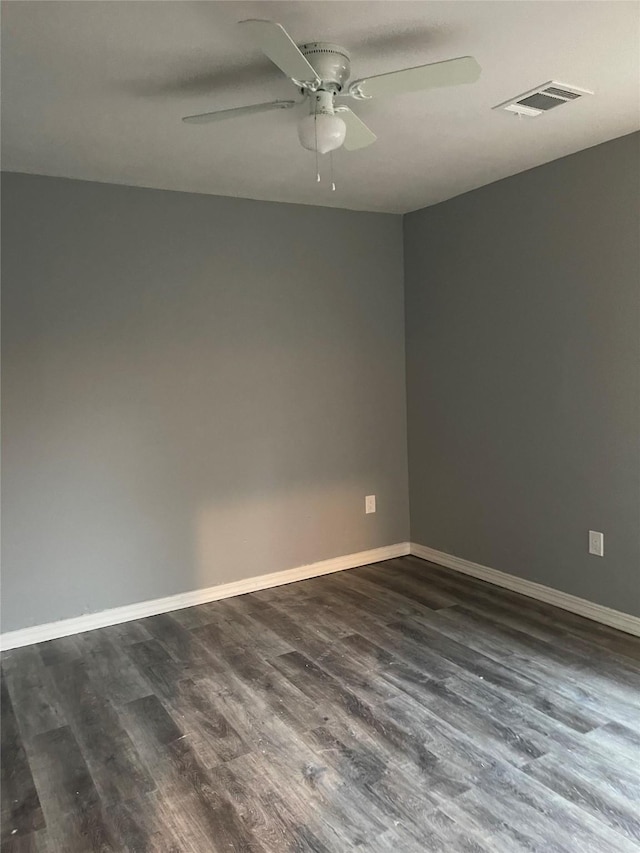 unfurnished room with dark wood-style flooring, ceiling fan, and baseboards
