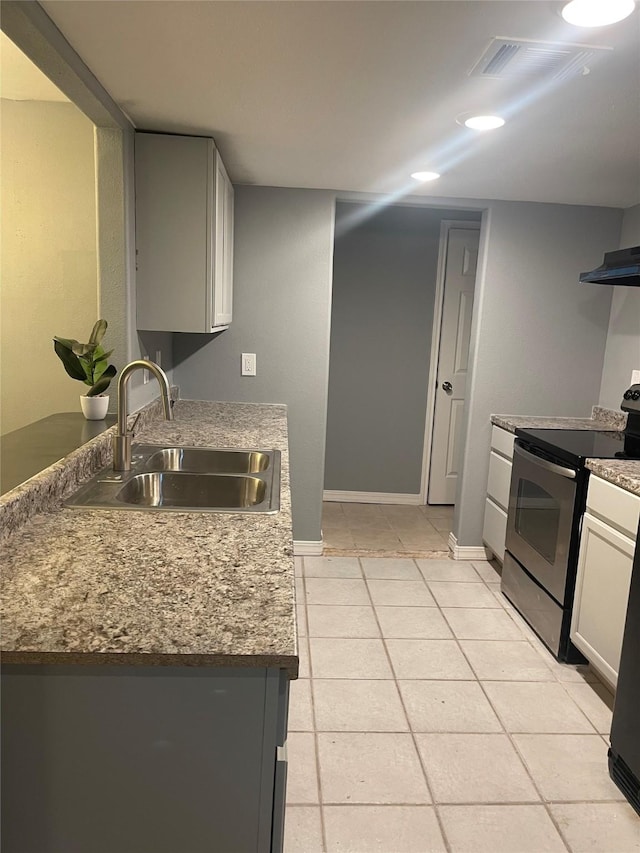 kitchen featuring stainless steel electric range oven, a sink, baseboards, stone countertops, and recessed lighting