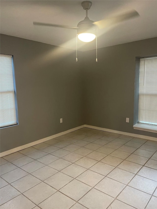 empty room featuring light tile patterned floors and baseboards