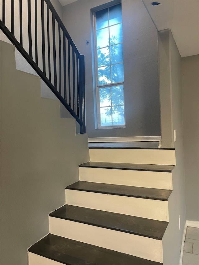 staircase featuring baseboards