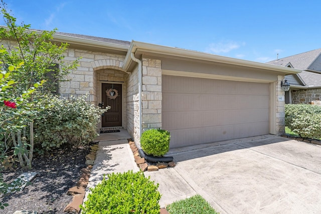 view of front of property with an attached garage, roof with shingles, concrete driveway, and stone siding