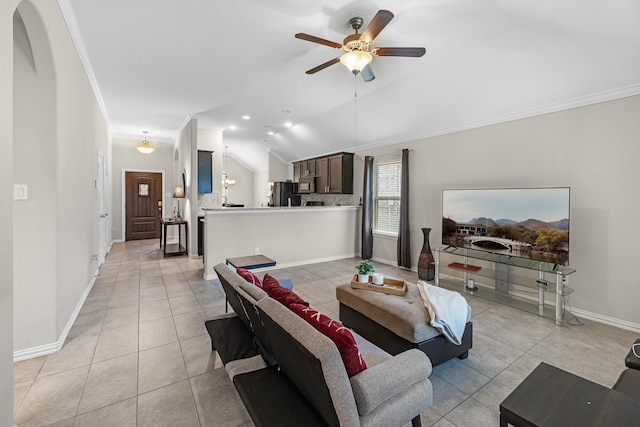 living area with ceiling fan, baseboards, light tile patterned flooring, ornamental molding, and vaulted ceiling