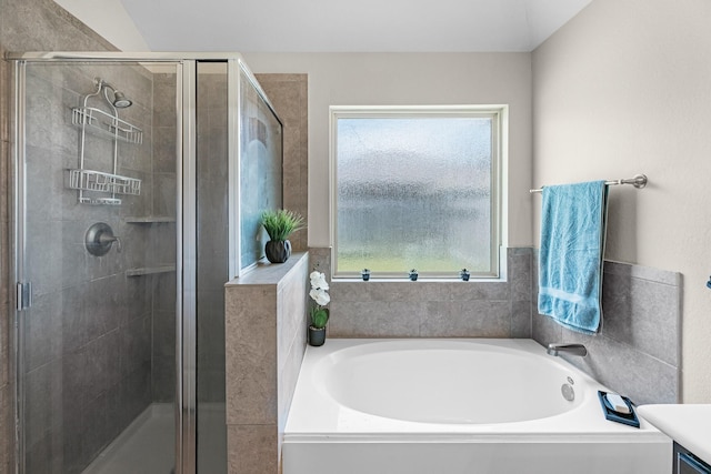 bathroom featuring a shower stall and a bath