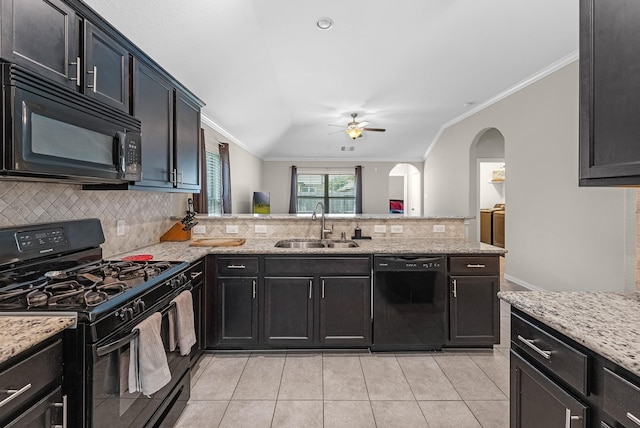 kitchen featuring a sink, tasteful backsplash, black appliances, a ceiling fan, and arched walkways