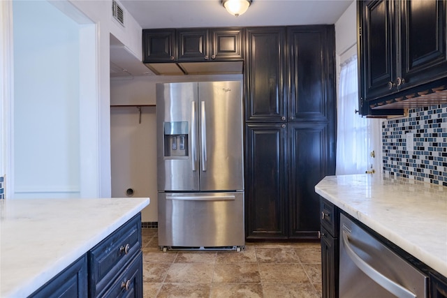 2574 Marilee Ln Unit 1, Houston, TX 77057 - kitchen with decorative backsplash, stone finish flooring, blue cabinets, visible vents, and appliances with stainless steel finishes