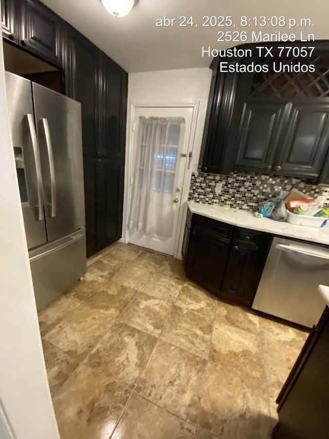 2574 Marilee Ln Unit 1, Houston, TX 77057 - kitchen featuring light countertops, dark cabinetry, tasteful backsplash, and stainless steel appliances