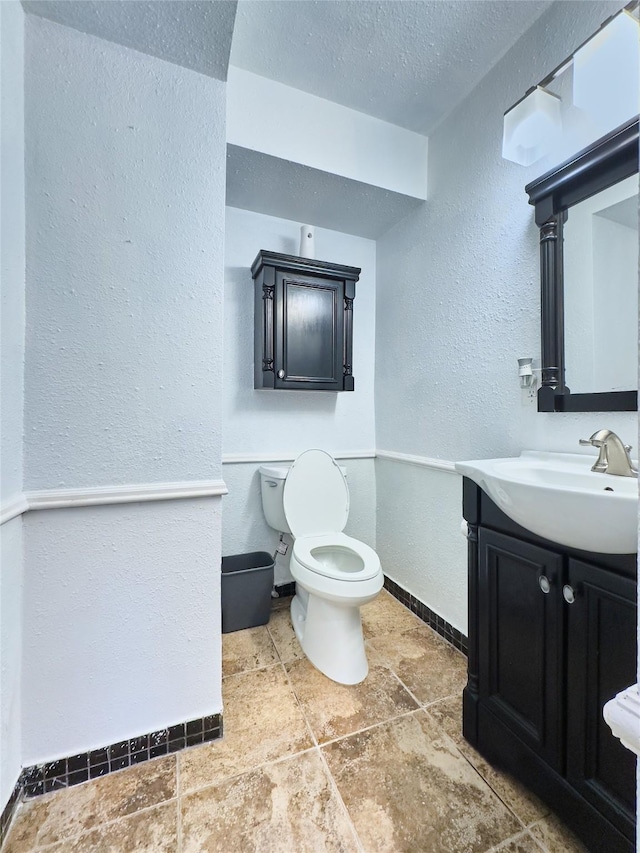 2574 Marilee Ln Unit 1, Houston, TX 77057 - half bathroom with a textured ceiling, baseboards, vanity, toilet, and a textured wall