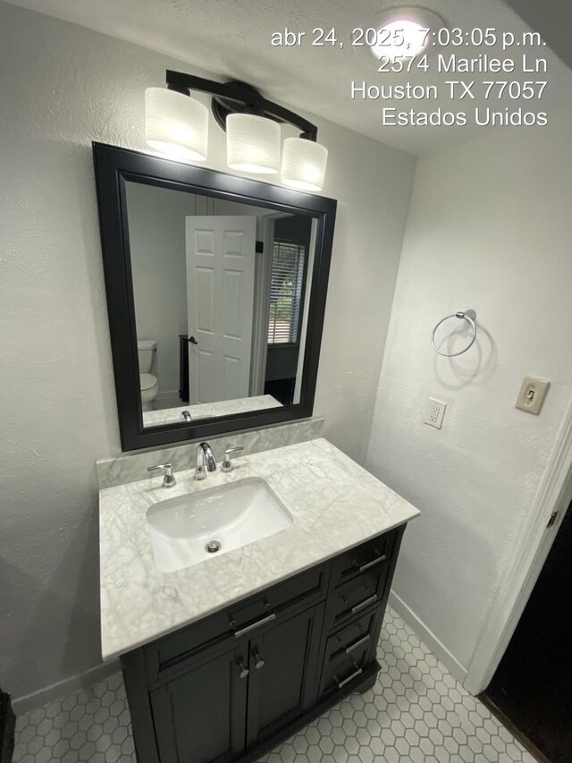 2574 Marilee Ln Unit 1, Houston, TX 77057 - bathroom featuring baseboards, a textured wall, toilet, and vanity
