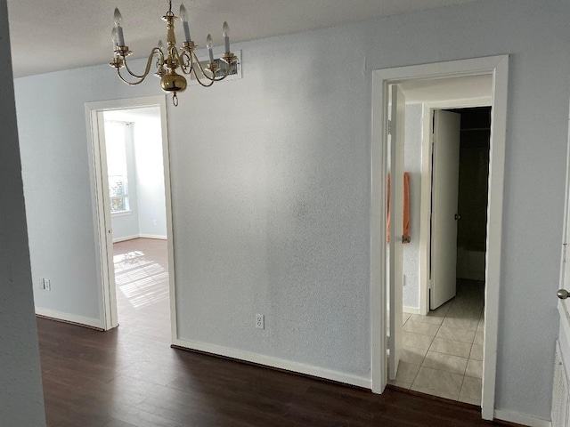 2333 Bering Dr Unit 201, Houston, TX 77057 - unfurnished dining area with a chandelier, baseboards, and dark wood-style flooring